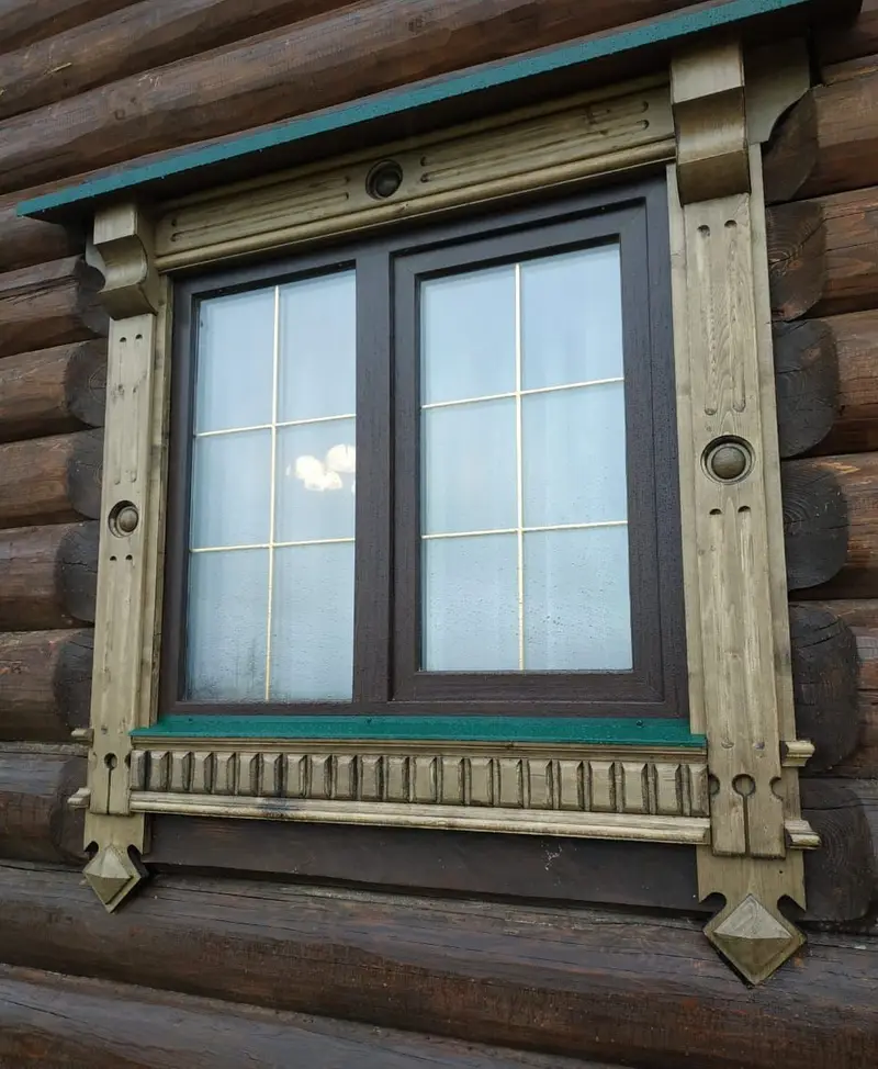 Резной деревянный наличник на окне сруба